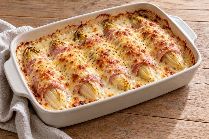 Endives au jambon gratinées dans un plat en céramique, béchamel dorée au comté