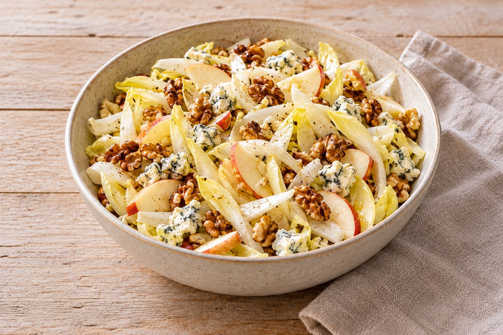 Salade d'endives avec pomme, cerneaux de noix grillés et bleu émietté, dans un saladier